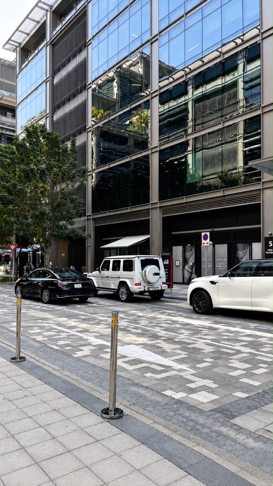 Street reference: modern glass building with parked cars
